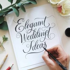 a person is writing on a piece of paper that says elegant wedding ideas with black ink