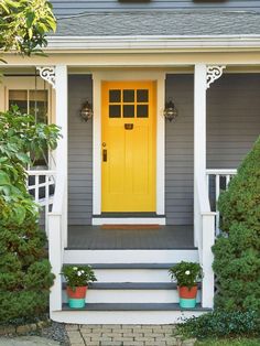 a yellow front door on a gray house