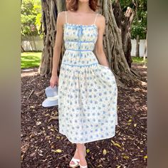 This Elegant Magnolia Floral Midi Dress Features A Beautiful Blue Flower Print And A Striking Contrast Baby Blue Lining. It Boasts A Sleek Straight Neckline, Adjustable Spaghetti Straps, And A Charming Center-Bust Bow Ribbon Detail. With Rows Of Delicate Gathering On The Upper To Mid-Body And A Flowy Midi Bottom, This Dress Is Sure To Make A Statement. Size Rec: 0-2 S 4-6 M 8 L Blue Flower Print, Ivory Flower, Bow Ribbon, Ivory Flowers, Straight Neckline, Blue Ivory, Floral Midi Dress, Blue Flower, Flower Print