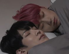 two people are sleeping together on the bed