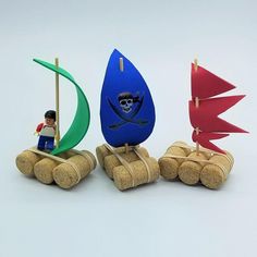 there are three toy boats with sails on them