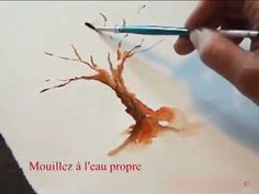 a person is painting a tree with watercolors