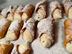 pastries are covered in powdered sugar and sit on a baking sheet, ready to be eaten