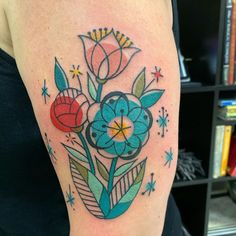 a colorful flower tattoo on the right arm and shoulder, with stars around it's edges