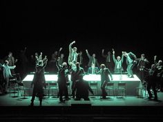 a group of people standing on top of a stage with their arms in the air