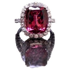 DeKara Designs Collection Metal- 18K White Gold, .750. Stones- Cushion Pinkish Red Tourmaline 8.40 Carats, 32 Round Diamonds, F-G Color VS1-VS2 Clarity, 1.20 Carats. Size- Ring is a 6 1/2. FREE SIZING!!!! A Breathtaking Luxurious 18K White Gold Tourmaline Halo Diamond Engagement/Wedding. This ring is entirely handmade with a exceptional cushion cut reddish pink colored tourmaline. The tourmaline is professionally set in between four prongs and surrounded by 20 French U pave set round diamonds. Each side of the ring has another six round French U pave set diamonds to give the ring a dazzling finish. The gallery work on the ring is amazing with wires running up from the ring's shank up to the halo portion. The ring is one of a kind! A truly dazzling heirloom piece that will be loved by all! Tourmaline Engagement Ring, Red Tourmaline, Contemporary Engagement Rings, Pinkish Red, Modern Engagement Rings, Gold Cocktail Ring, Diamond Cocktail Rings, Gold Halo, White Gold Diamond Rings