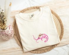 "Embroidered Shrimp Sheriff T-shirt It is all about the right color thread and you have the perfect minimalist Comfort Colors T-shirt. This wave t-shirt is very soft and high quality embroidered with the very quality threads. It is perfect for any occasion. It is a perfect gift for that cowgirl person in your life. ---Features--- 🌺 6.1 oz., 100% ringspun cotton 🌺 Preshrunk, soft-washed, garment-dyed fabric 🌺 1\" ribbed collar with double-needle topstitched neckline 🌺 Double-needle stitched s Pink Crew Neck T-shirt With Machine Embroidery, Tshirt For Women, Comfort Colors Tshirt, Funny Tshirt, Dyed Fabric, Dusty Blue, Graphic Shirts, Tshirt Colors, Cute Gifts