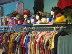 there are many hats and shirts on the rack