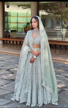 a woman in a wedding outfit standing outside