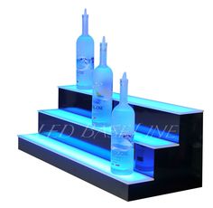 three bottle display stands with led lights on each shelf and bottles in the bottom tier