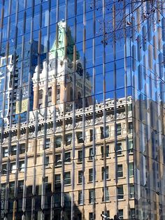 the building is reflected in the windows of it's glass frontage and clock tower