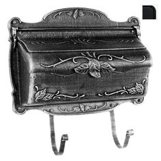 an old fashioned metal mailbox with a flower decoration on the front and side, hanging from