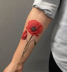 a woman's arm with two red flowers on it