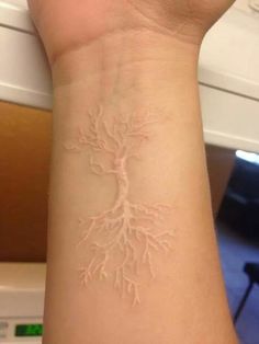 a person's arm with a tattoo on it that has a tree growing out of it