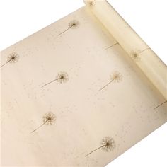 a sheet of paper with dandelions on it and a roll of parchment next to it