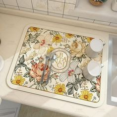 a kitchen counter with a flowered place mat and utensils