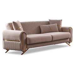 a couch with two pillows on it and some gold trim around the armrests