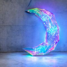 an illuminated sculpture in the shape of a crescent