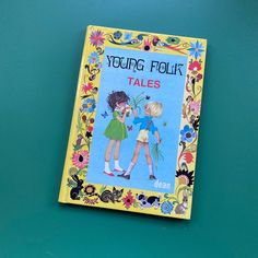 a children's book about young folk tales on a blue background with flowers and leaves