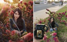 a woman sitting on the side of a road next to flowers and holding a camera