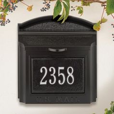 a black mailbox mounted to the side of a wall