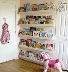 a toy horse is standing in front of a book shelf with books on the shelves