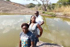 two women and a man are standing by the water