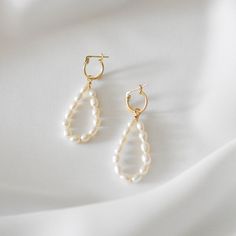 These earrings feature a dangling, teardrop shape. Made of 14K gold filled materials and genuine freshwater pearls, these earrings are tarnish-resistant, water-resistant, and hypoallergenic. Earring length measures approximately 2 inches long and can be customized shorter or longer by leaving a note at checkout. --------------------♥ PROMOS ♥-------------------- Want 10% off? Join the mailing list by visiting http://bit.ly/vedern . Just leave me a note at checkout if you have any problems applyi White Teardrop Hoop Earrings As Gift, Everyday Teardrop Earrings With Pearl Charm, Handmade Minimalist Pearl Drop Earrings, Handmade Minimalist Drop Pearl Earrings, Everyday Dangle Pearl Earrings With Ear Wire, Everyday Dangle Pearl Earrings, Classic White Drop Chandelier Earrings, Pearl Teardrop Chandelier Earrings For Pierced Ears, Dainty Pearl Charm Teardrop Earrings