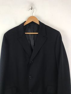 "-Description- >men's black wool overcoat >collared >three button front >two flap close pockets on the front >two buttons on the cuffs >lined >vent in the back >size large >perfect for a business coat! >condition: great >color(s): black >fabric(s): wool >brand: hymans clothes >care: dry clean -Measurements- >size: large ✩ all measurements are taken with the item laying flat & some sizes are estimates so please check measurements ✩ chest: 48\" / 12 Classic Black Outerwear With Single Button, Classic Black Long Coat Blazer, Classic Long Black Blazer, Black Single Button Business Outerwear, Black Business Outerwear With Suit Collar, Black Long Wool Coat For Business, Classic Black Sport Coat With Hidden Button Closure, Black Wool Sport Coat With Suit Collar, Black Wool Coat With Lapel Collar For Business