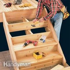 a man standing on top of a wooden stair case next to a table with tools