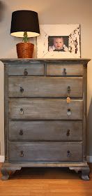 an old dresser is painted gray and has a photo on the top with a baby's head