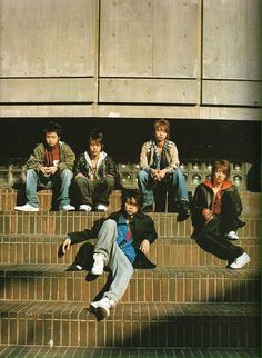 group of young men sitting on steps in front of building