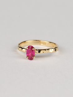 This oval ruby ring is truly exceptional, combining refined design with minimalist charm. It is a timeless piece that is both classically elegant and strikingly modern. The warm tone of the gold beautifully complements the deep red-pink hue of the ruby, creating a stunning contrast that captures attention. The centerpiece of this ring is a gorgeous 0.6-carat ruby sourced from Tanzania. The fluid design of the band reflects light brilliantly, adding a contemporary touch to this exquisite piece. T Modern Oval Ruby Ring For Wedding, Timeless Oval Ruby Promise Ring, Minimalist Oval Ruby Wedding Ring, Minimalist Oval Ruby Ring For Anniversary, Minimalist Oval Yellow Gold Ruby Ring, Minimalist 14k Gold Oval Ruby Ring, Minimalist Oval Ruby Ring In Yellow Gold, Modern Oval Ruby Ring, Oval Ruby Ring