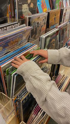 a woman reaching for cds in a record store