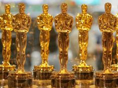 the oscars are lined up on display in front of a glass case with gold statues