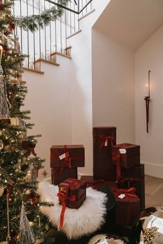 presents under the christmas tree are wrapped in red and gold ribbon