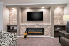 a living room filled with furniture and a flat screen tv mounted on the wall above a fire place