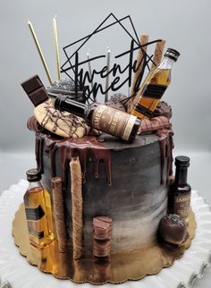 a birthday cake decorated with liquor bottles and chocolate icing on a white platter