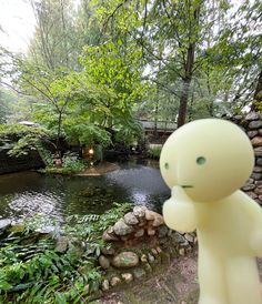 a toy is standing in front of a pond