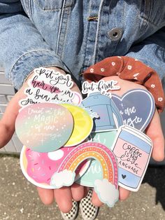 someone holding several stickers in their hands with the words on them and rainbows