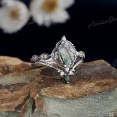 a white diamond ring sitting on top of a rock