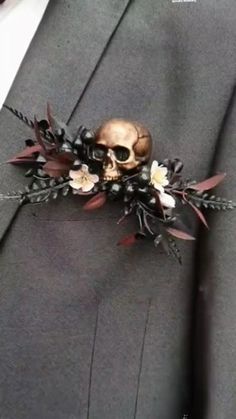 a man in a suit with a skull and flowers on it's lapel