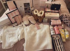 an assortment of items are laid out on a bed with pink and white sheets in the background