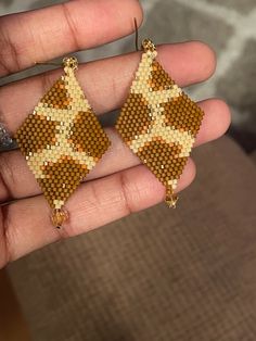 someone is holding up their hand made beaded earrings