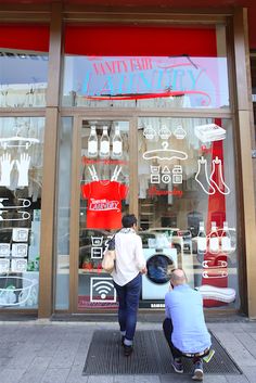 two people sitting in front of a store window