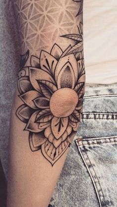 a woman's arm with a tattoo on it and a flower in the middle