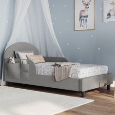 a child's bed in a bedroom with blue walls and white polka dot wallpaper