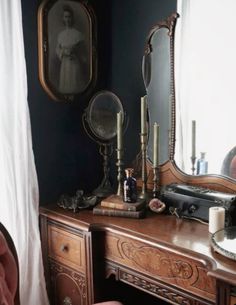 an old fashioned vanity with two mirrors and candles