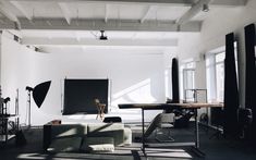 an empty room with couches and lighting equipment on the floor in front of a projector screen