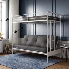 a futon bunk bed in a room with blue walls and wooden floors, white furniture